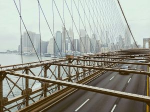 View of a city skyline from a bridge, with sparse traffic on the road, symbolizing urban infrastructure and the potential for green IT to reduce carbon emissions in densely populated areas.