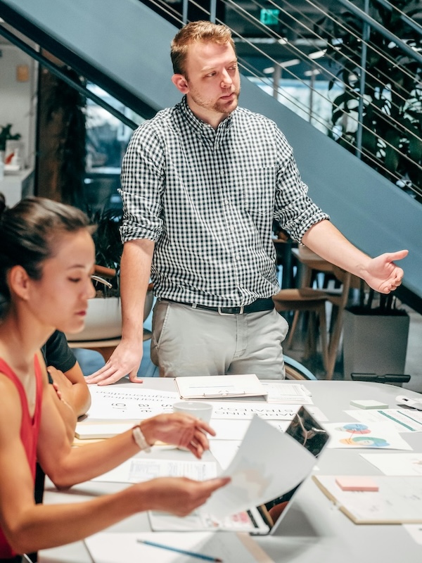 A team leader presenting ideas to colleagues during a meeting, discussing strategies for implementing Green IT and sustainable software development to enhance business operations.