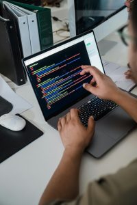 A male developer working on code in his laptop.