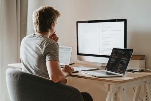 A man reading about International trends and themes in AI regulation on his computer. 